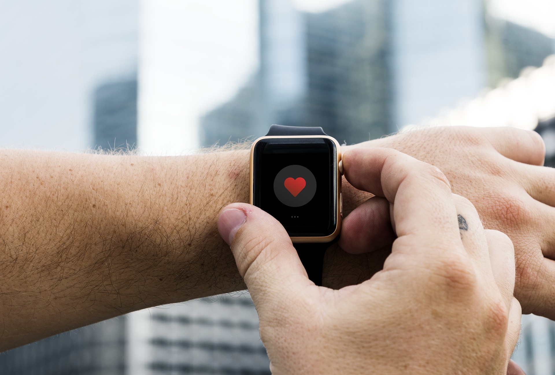 montre connectée avec coeur affiché sur l'écran au poignées d'un bras d'homme